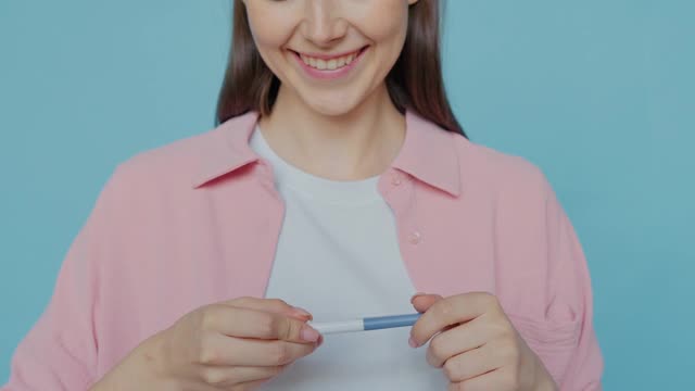 笑顔で妊娠検査薬を見せる女性の鼻から下の動画｜無料の動画素材サイト