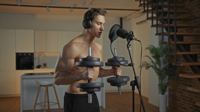 マイクに向かって話しながら筋トレしているトップレス男性の動画｜無料の動画素材サイト