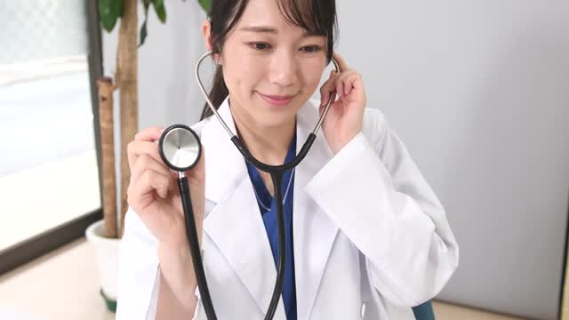 聴診器を持ち診察する白衣姿のアジア人女性の動画｜無料の動画素材サイト