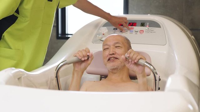 機械浴で入浴介助を受けるアジア人高齢者の動画|無料の動画素材サイト「動画AC」