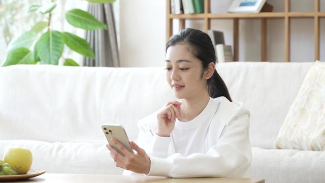 座ってよそ見して頷きながら携帯を見ている女性の動画|無料の動画素材サイト「動画AC」